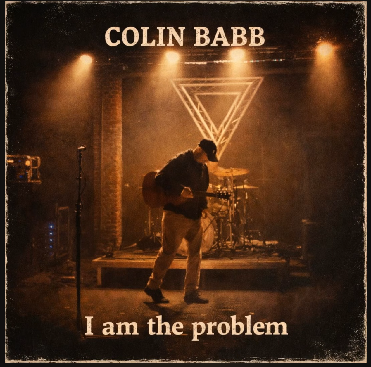 Colin Babb album cover, I am the problem, showing a musician performing under warm stage lights